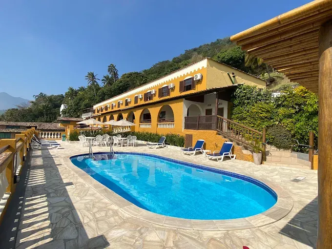 Piscina e fachada amarela do Hotel Colonial em Ilhabela